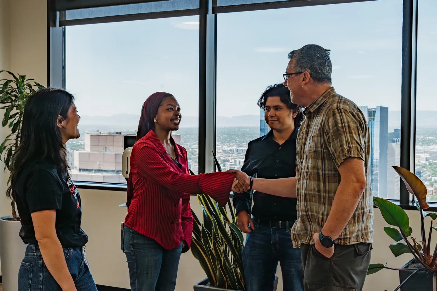 A HighView student shakes hands with a professional during an employer office visit in Denver